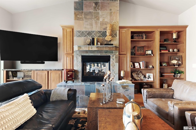 living room with lofted ceiling and a tiled fireplace