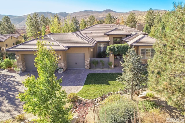 view of front of property featuring a mountain view, a garage, and a front lawn