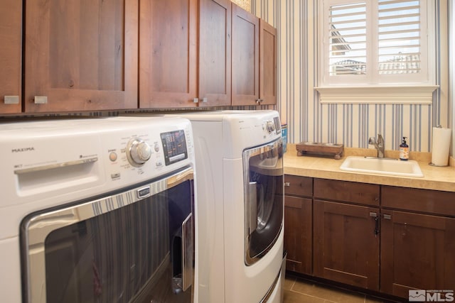 laundry room with tile patterned floors, cabinets, sink, and washing machine and clothes dryer