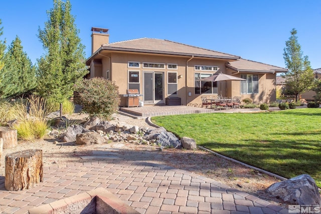 back of property featuring a yard and a patio area