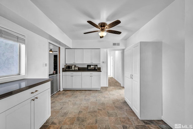 kitchen featuring white cabinetry and ceiling fan