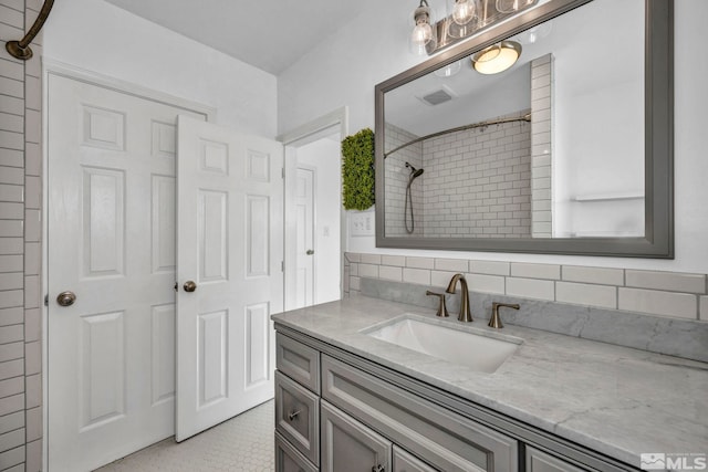 bathroom featuring vanity, decorative backsplash, tile patterned floors, and walk in shower