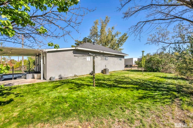 back of house with central AC and a lawn