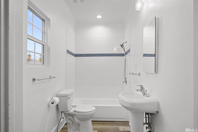 full bath with toilet, wood finished floors, and  shower combination