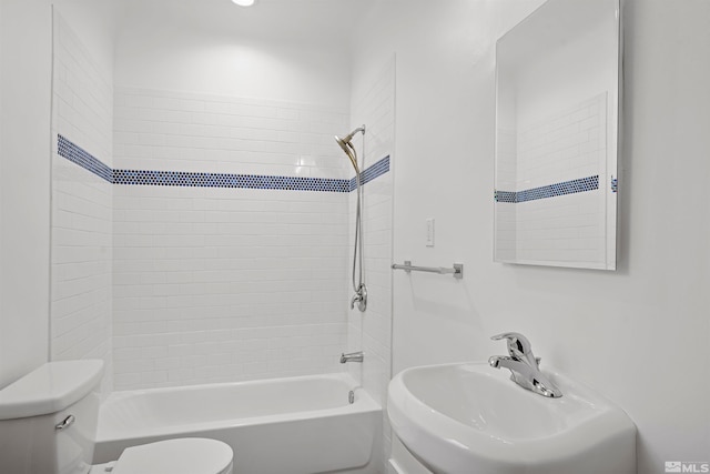 full bathroom with toilet, tiled shower / bath combo, and sink