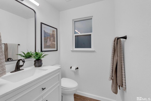 bathroom with vanity, toilet, and hardwood / wood-style flooring