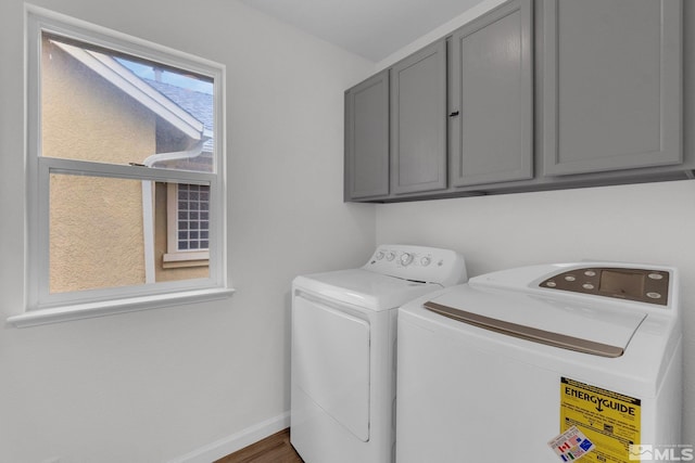 laundry area featuring cabinets, washer and dryer, and dark hardwood / wood-style flooring