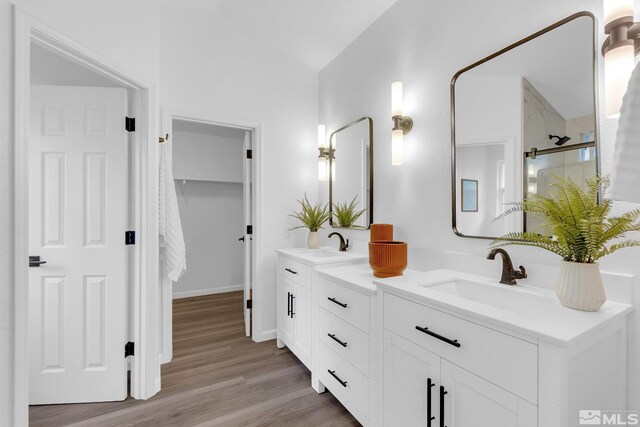 bathroom featuring vanity, hardwood / wood-style flooring, and a shower with shower door