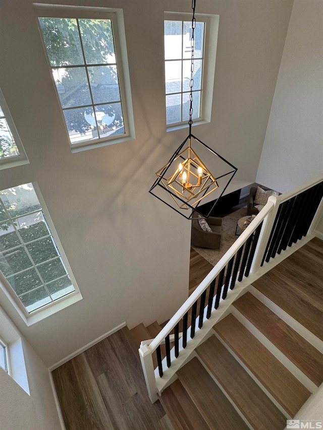 stairway featuring a notable chandelier and hardwood / wood-style flooring