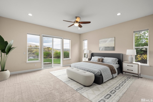 carpeted bedroom featuring access to outside, multiple windows, and ceiling fan