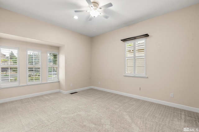 unfurnished room featuring light carpet and ceiling fan