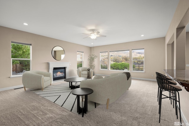 carpeted living room with a healthy amount of sunlight and ceiling fan