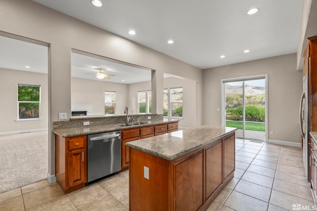 kitchen featuring sink, dishwasher, a center island, and stone countertops