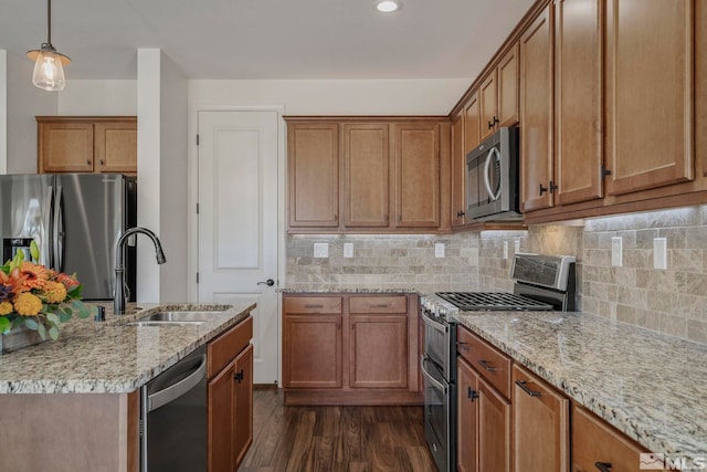 kitchen featuring hanging light fixtures, sink, dark hardwood / wood-style flooring, appliances with stainless steel finishes, and tasteful backsplash