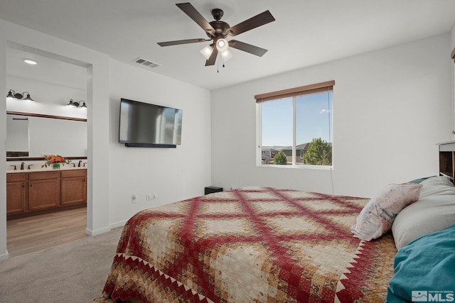 carpeted bedroom with sink, ceiling fan, and ensuite bathroom