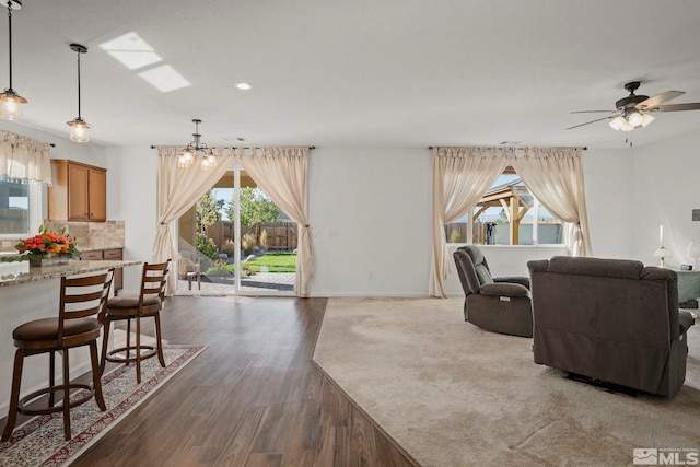 living room featuring ceiling fan, plenty of natural light, and dark hardwood / wood-style floors