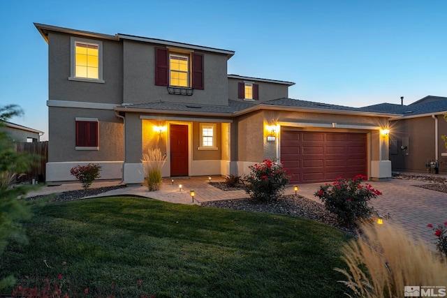 view of front of home with a yard and a garage