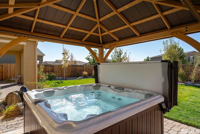 view of patio / terrace featuring a hot tub and a gazebo