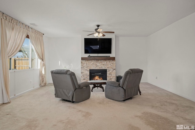 living room featuring ceiling fan, carpet, and a fireplace