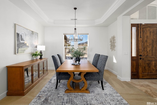 dining room with crown molding, light colored carpet, and a tray ceiling