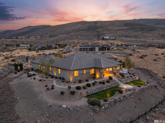 aerial view at dusk featuring a mountain view