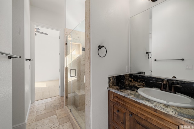 bathroom featuring vanity, ceiling fan, and a shower with door