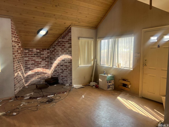 unfurnished living room with wooden ceiling, high vaulted ceiling, wood-type flooring, and brick wall