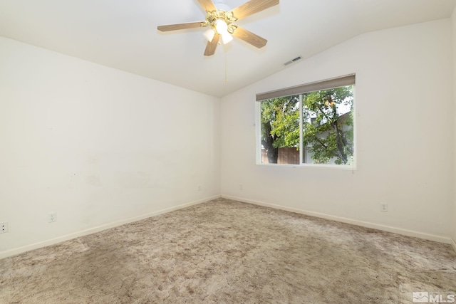 empty room featuring lofted ceiling, carpet, and ceiling fan