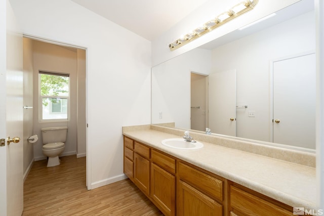 bathroom featuring toilet, hardwood / wood-style floors, and vanity