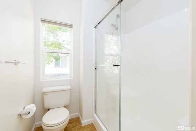 bathroom with toilet, an enclosed shower, and wood-type flooring