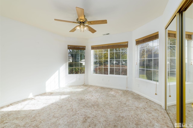 unfurnished sunroom featuring ceiling fan and a wealth of natural light