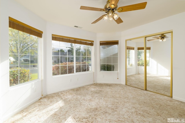 unfurnished sunroom featuring ceiling fan