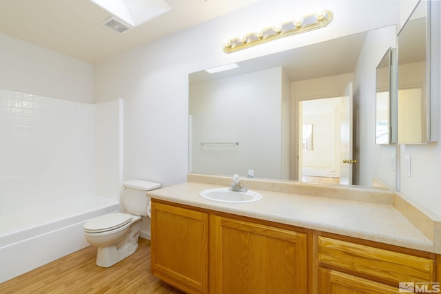 full bathroom featuring vanity, wood-type flooring, toilet, and shower / bath combination