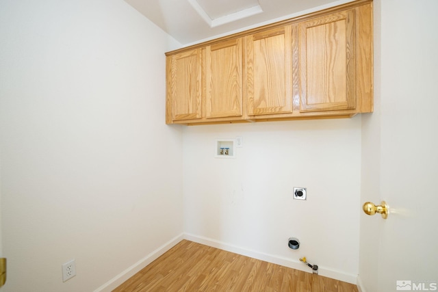 laundry room with hookup for a washing machine, light hardwood / wood-style flooring, hookup for an electric dryer, gas dryer hookup, and cabinets