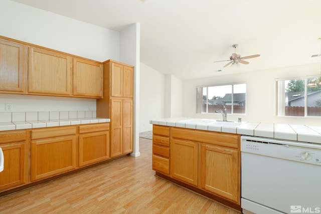 kitchen featuring ceiling fan, tile countertops, white dishwasher, light hardwood / wood-style flooring, and sink