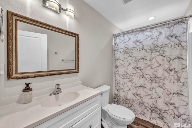 bathroom featuring vanity, hardwood / wood-style floors, a shower with curtain, and toilet