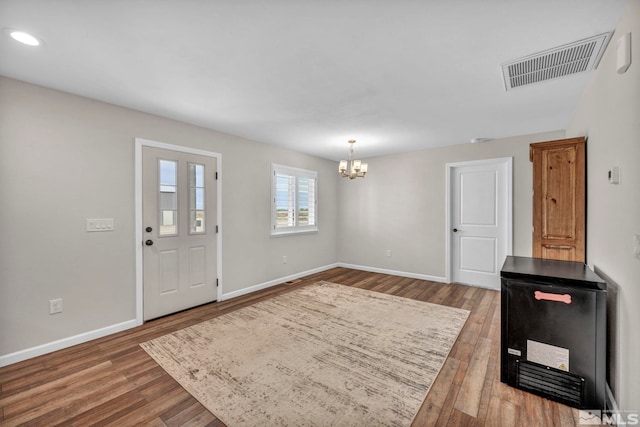 entrance foyer with hardwood / wood-style floors and a chandelier