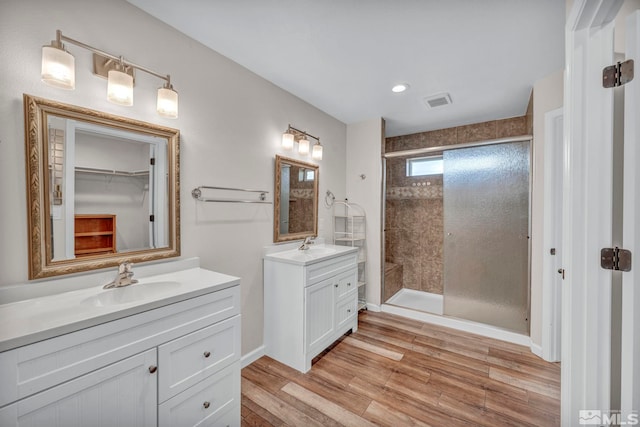 bathroom with vanity, walk in shower, and wood-type flooring