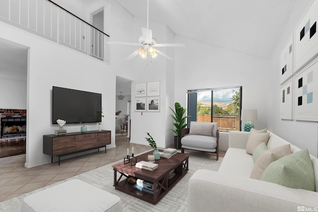 living room featuring a fireplace, light tile patterned floors, high vaulted ceiling, and ceiling fan