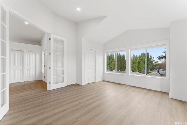 interior space featuring light hardwood / wood-style floors, french doors, and lofted ceiling