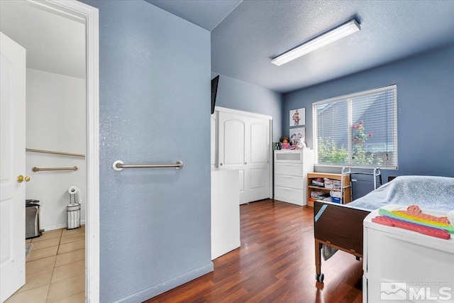 bedroom with a textured ceiling and wood-type flooring