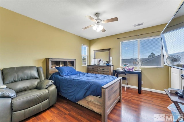 bedroom featuring dark wood-type flooring, ceiling fan, and multiple windows