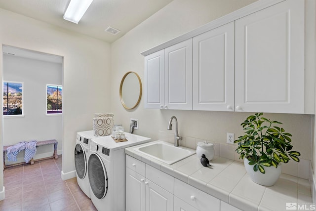 washroom featuring cabinets, light tile patterned flooring, washer and dryer, and sink