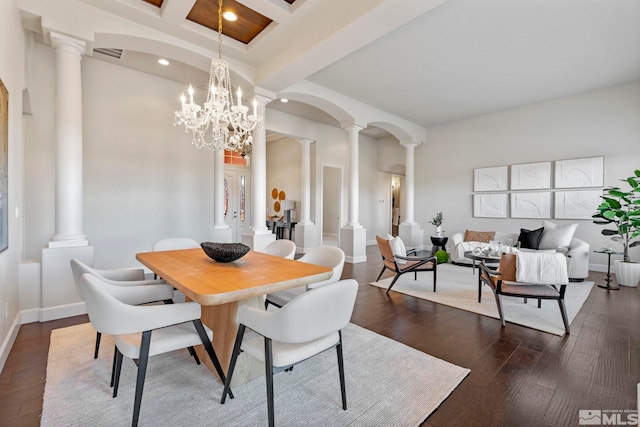 dining space featuring dark wood-type flooring, decorative columns, beamed ceiling, and a chandelier