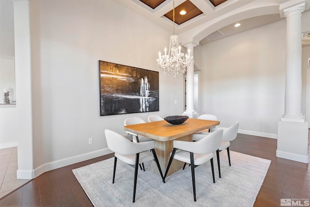 dining area with coffered ceiling, beam ceiling, dark wood-type flooring, decorative columns, and a chandelier