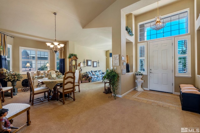 entrance foyer with a notable chandelier, light colored carpet, and a high ceiling