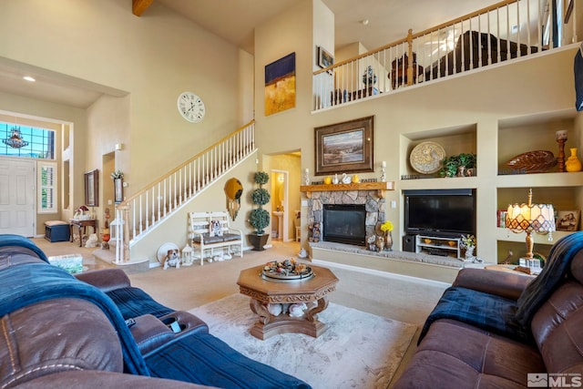 carpeted living room featuring a high ceiling and a stone fireplace