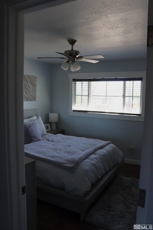 bedroom with a textured ceiling and ceiling fan