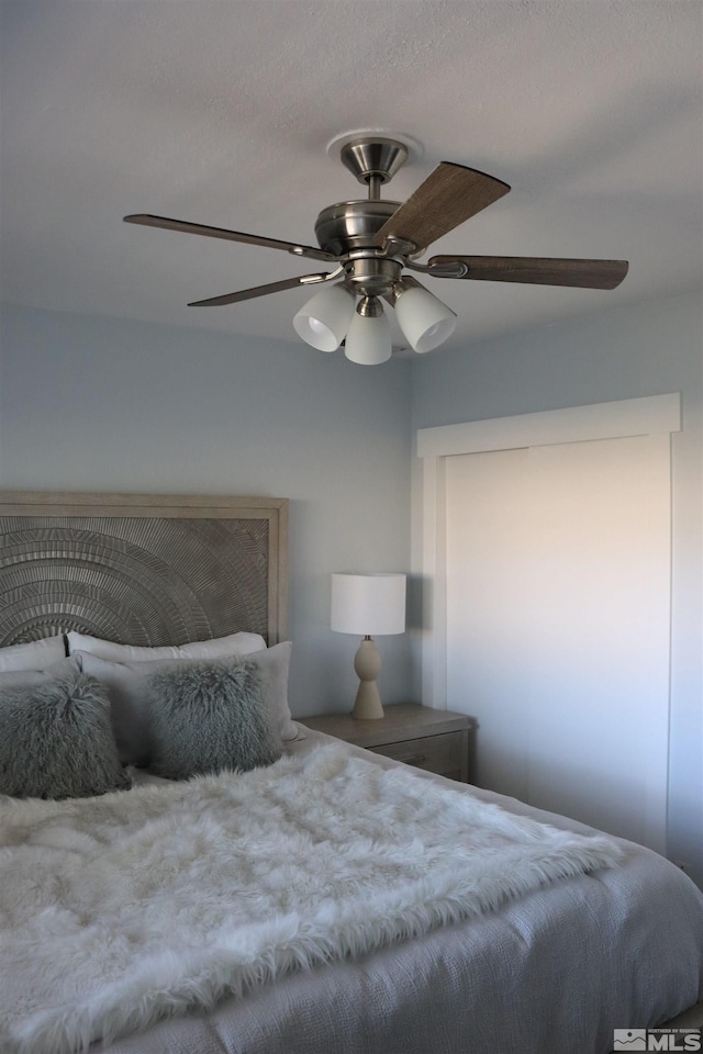 bedroom featuring ceiling fan and a textured ceiling