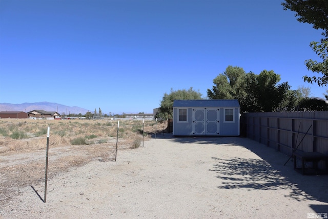 view of yard featuring a mountain view and a storage shed